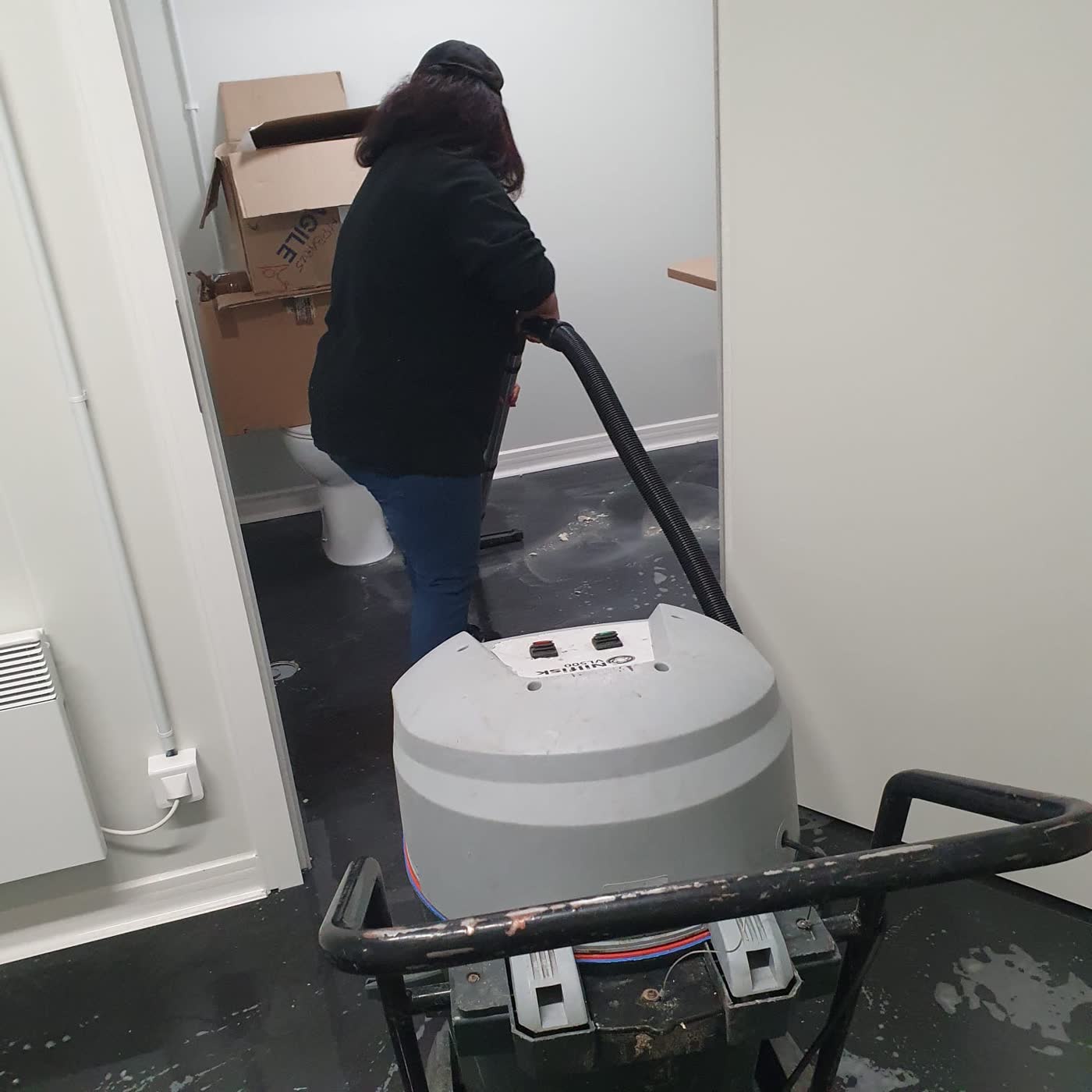 Nettoyage mécanisé d'un sol de sanitaires par une équipe FARKAS