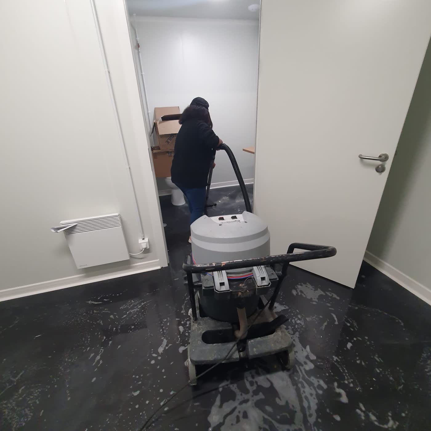 Agent FARKAS nettoyant un sol de locaux à la monobrosse avec aspiration
